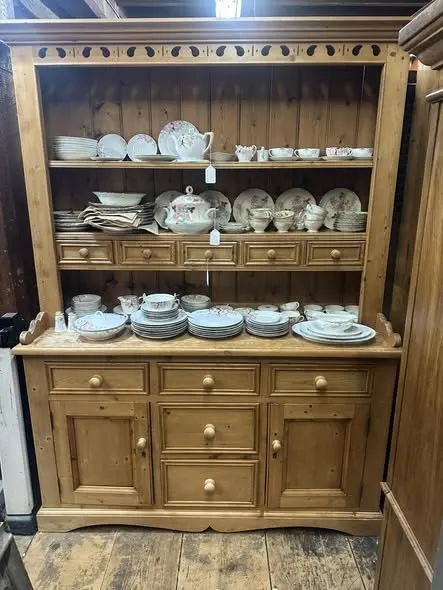 Pine hutch with a plate rack full of white china