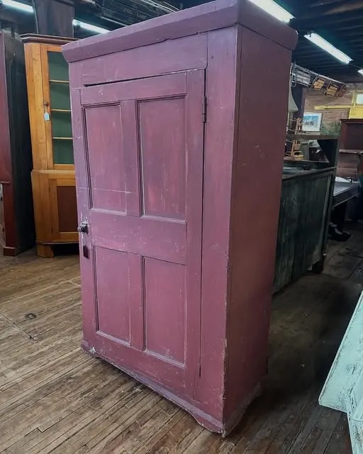Tall country cupboard with worn red paint