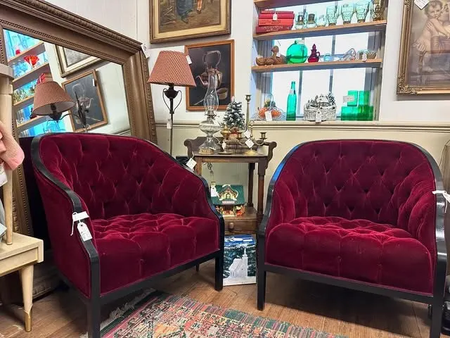 A pair of tufted red velvet club chairs